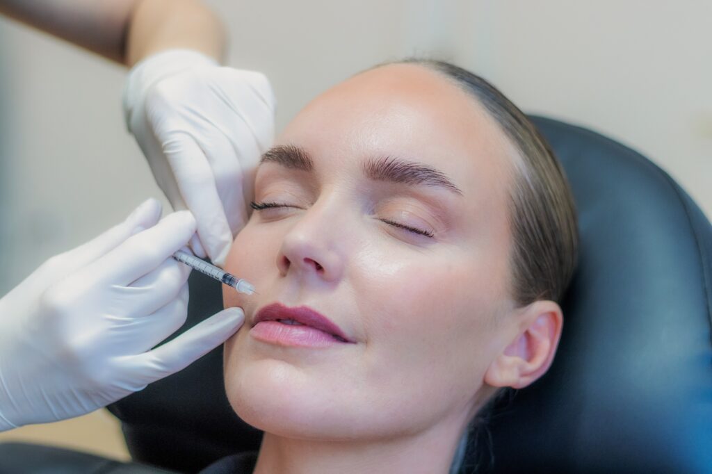 Behandler giver botox ved mundvigen med en tynd insulinsprøjte, kvinden ligger afslappet i behandlingsstolen