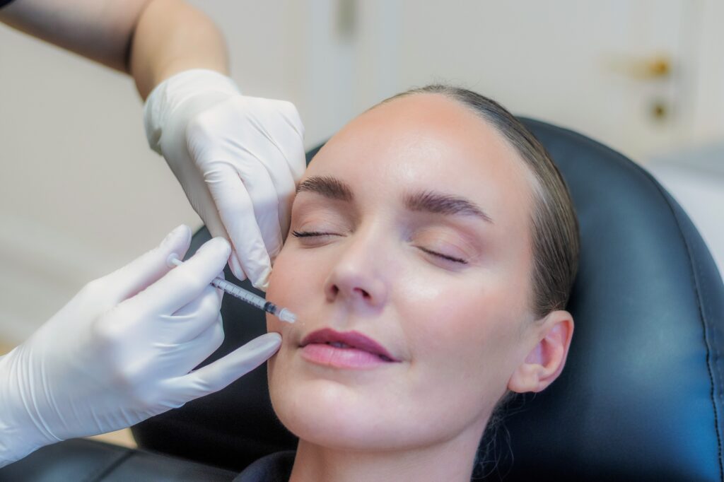 Behandler giver botox ved mundvigen med en tynd insulinsprøjte, kvinden ligger afslappet i behandlingsstolen