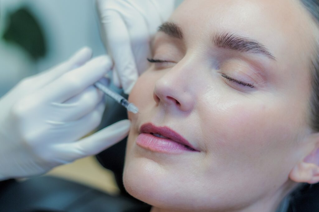 Behandler giver botox ved mundvigen med en tynd insulinsprøjte, kvinden ligger afslappet i behandlingsstolen
